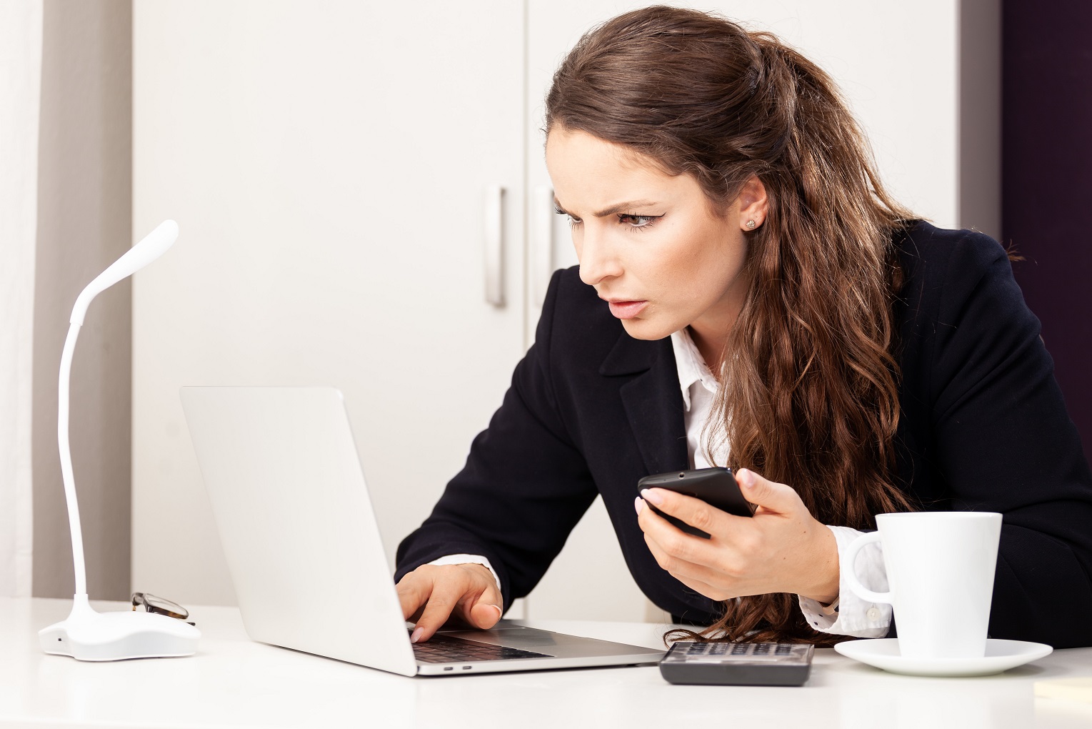 woman looking stressed at her computer fraud risk awareness